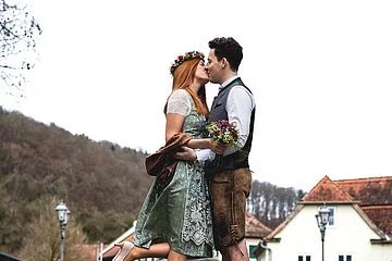 Beispielbild - Brautpaar in Tracht küsst sich auf Brücke