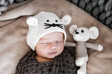 Beispielbild - Baby in Kuscheldecke mit Kuscheltier