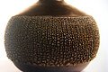 Töpeferarbeit. Eine Vase, hat römischen Charakter, braun mit Verzierungen im mittleren Bereich des Körpers.