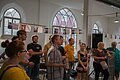 Bergüßungsrede bei der Vernissage, Besucher schauen in Richtung des Sprechers.
