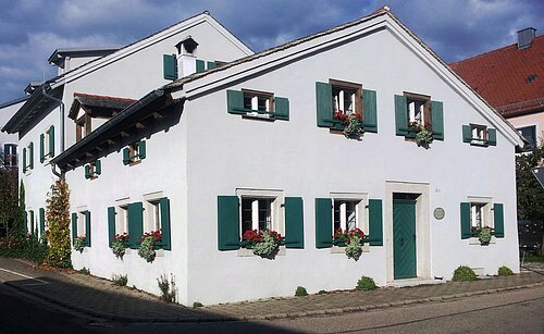Ferienhaus Schwimmer in Treuchtlingen Das Jurahaus mit seinen grünen Fensterläden und Haustür ist schmuck. Die Fenstersimse zieren Blumenkästen.
